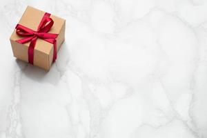 Present with pink ribbon on marble background with copyspace. Minimalistic composition for the holidays photo