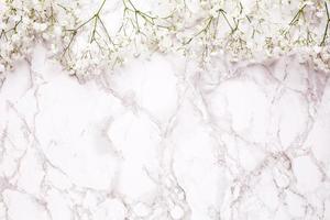 Floral frame of white flowers on marble table top view and flat lay style. photo