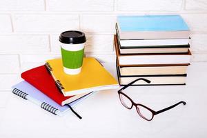 Education literature and notebooks with accessories on workplace near brick wall. Top view and selective focus. photo