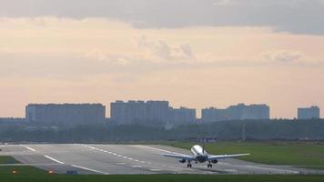 el avión llega al aeropuerto de moscú, vuelo matutino al amanecer. avión de aterrizaje en el fondo de un hermoso panorama de la ciudad video
