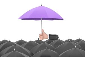 Uniqueness and individuality. Hand holding a purple umbrella among people with black umbrellas. photo