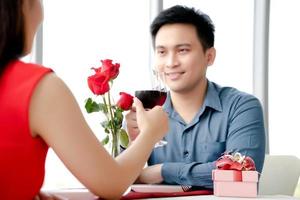 mujer atractiva brindando con una copa de vino tinto con su novio en el restaurante foto