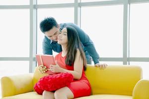 Boyfriend kissing his girlfriend and giving her a gift photo