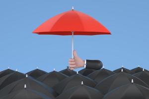 Uniqueness and individuality. Hand holding a red umbrella among people with black umbrellas. photo