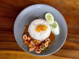 una ración de calamares agridulces con arroz y pepino. comida asiática. foto