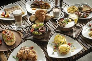 many mixed western breakfast food items on cafe table photo