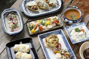 selection of many different tapas on rustic wood table photo