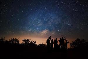 Landscape with milky way, Night sky with stars and silhouette of happy people standing on Doi Luang Chiang Dao high mountain in Chiang Mai Province, Thailand. photo