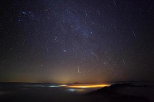 meteoro gemínido en el cielo nocturno y niebla en el punto de vista de khao takhian ong en khao-kho phetchabun, tailandia foto