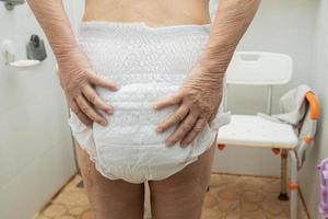 Asian senior or elderly old lady woman patient wearing incontinence diaper in nursing hospital ward, healthy strong medical concept. photo