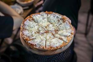 cheesy ham pizza top up with oregano on woman hand., Foodtrack event in Bangkok, Thialand. photo