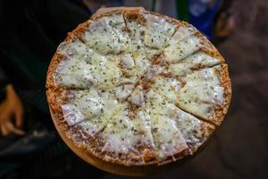 cheesy ham pizza top up with oregano on woman hand., Foodtrack event in Bangkok, Thialand. photo