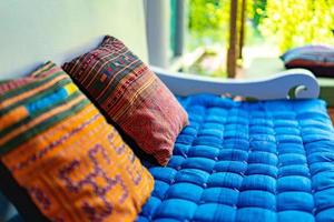 almohada de descanso en el suave sofá cama azul al aire libre en el jardín. foto