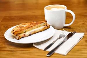 Sandwish and coffee on the wood table in the morning. photo