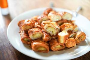 a banana snack and almond in honey ready to eat, and topping Sweetened condensed milk before eat. photo