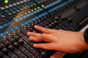 DJ hand on sound control console. photo