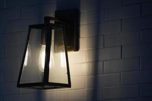 Square steel lamp tungsten warm light on the white brick wall. photo