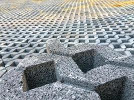 gray color stone brick block floor tile with green grass and sand as background or texture. photo