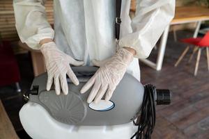 el rociador de agua de la máquina esterilizadora está en espera y listo para usar por parte del personal profesional con traje de prevención y guantes de goma para prevenir y proteger el coronavirus covid19. foto