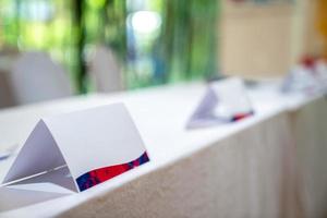 Standy triangle paper stands on the white cover table for identify the name of committee in business presentation contest event. photo