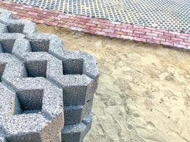 gray color stone brick block floor tile with green grass and sand as background or texture. photo