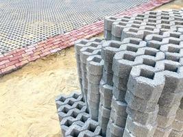 gray color stone brick block floor tile with green grass and sand as background or texture. photo