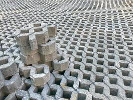 Baldosas de suelo de ladrillo de piedra de color gris con hierba verde y arena como fondo o textura. foto