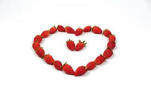 Heart shape of strawberries in the line. Red fresh strawberry in studio light on the pure white background. photo