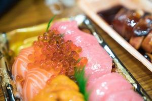 sushi Salmon and others sushi are arranged in foam plant on the table ready to eat at Kuromon Fish Market, Osaka, Japan photo