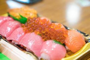 sushi Salmon and others sushi are arranged in foam plant on the table ready to eat at Kuromon Fish Market, Osaka, Japan photo