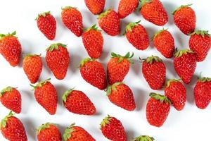 Fresh luxury Strawberry are disrupted in the group area with studio light on the white background. photo