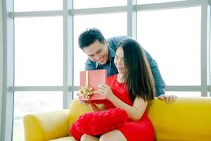 Happy married couple man and woman give a gift for holiday photo