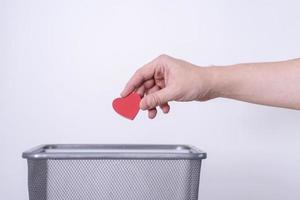 Handmade wooden heart tossed in the trash for recycling and disposal. photo