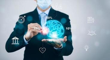 Businessman wearing mask touch brain icon and line control in graph Screen Icon of a media screen,Technology Process System,Concept Futuristic medicine,human body,brain with Online consultation. photo
