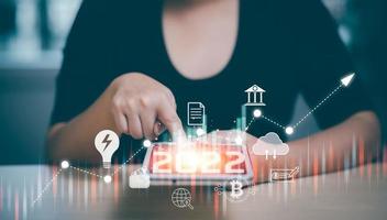 2022 and Startup concept with icon business and network connection on modern virtual interface from digital tablet.woman Touching tablet and graph Screen Icon of media screen, Technology Process photo