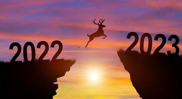 bienvenido feliz navidad y feliz año nuevo en 2023 con silueta de ciervo. foto