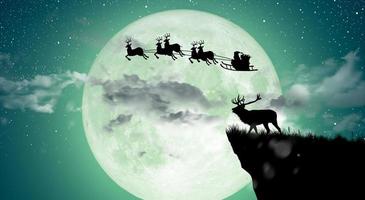 Silhouette of Santa Claus flying over the full moon. photo