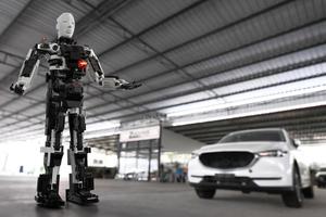 Robot Technology AI fix car repair on car Lift in garage dealership Fix the car with a touch touching UI screen interface point to the point that needs to corrected New technology in IOT car industry photo