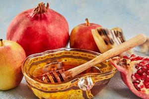 Rosh hashanah - jewish new year holiday concept. Apple-shaped bowl with honey, apples, pomegranates, a shofar are traditional symbols of the holiday photo