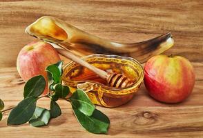 rosh hashanah - concepto de vacaciones de año nuevo judío. un cuenco con forma de manzana con miel, manzanas, un shofar son símbolos tradicionales de la festividad. foto