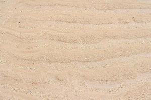 Sand texture. Sandy beach for background. Top view. Natural sand stone texture background. Wavy sand background for summer designs. photo