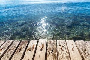 The wood floor extends into the sea. space for product or object presentation photo