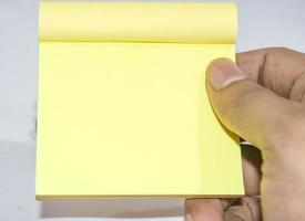 cuaderno pequeño de color amarillo para escribir algo sobre fondo blanco. foto