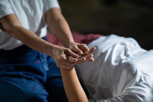 masaje y spa tratamiento relajante del síndrome de la oficina estilo tradicional de masaje tailandés. asain, masajista femenina senior que hace masajes, trata la mano, el dolor de espalda, el dolor de brazos, los pies y el estrés de las ancianas cansadas. foto