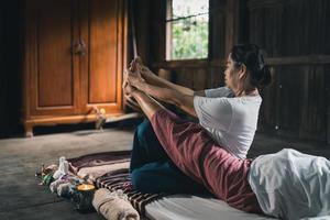 masaje y spa tratamiento relajante del síndrome de la oficina estilo tradicional de masaje tailandés. asain, masajista femenina senior que hace masajes, trata la mano, el dolor de espalda, el dolor de brazos, los pies y el estrés de las ancianas cansadas. foto