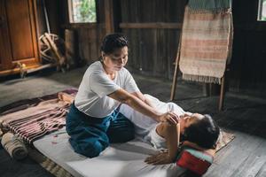 Massage and spa relaxing treatment of office syndrome traditional thai massage style. Asain senior female masseuse doing massage treat hand, back pain, arm pain, foot and stress for old woman tired. photo