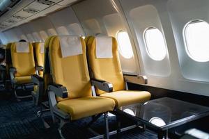 asientos de avión de pasajeros en la cabina. interior del avión comercial en sus asientos durante el vuelo sección de pasajeros de clase económica del avión. foto