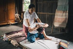 masaje y spa tratamiento relajante del síndrome de la oficina estilo tradicional de masaje tailandés. asain, masajista femenina senior que hace masajes, trata la mano, el dolor de espalda, el dolor de brazos, los pies y el estrés de las ancianas cansadas. foto