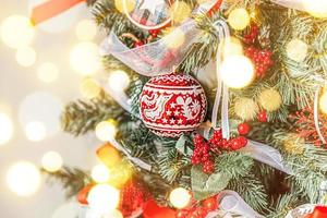 Classic Christmas New Year decorated New year tree with red and white ornament decorations toy and ball. Modern classical style interior design apartment. Christmas eve at home. photo