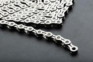 cadena de plata de una bicicleta de carretera sobre un fondo de textura oscura foto
